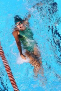 bird eye view of female swimmer doing backstroke in pool