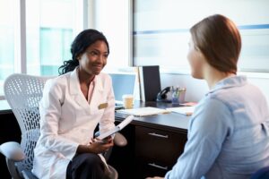 Femme médecin interrogeant un patient dans un bureau.