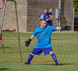 Teenage soccer goalie covering his net