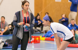 A Indigenous coach and her athlete talk during a competition