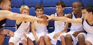 Male High School Basketball Team Having Team Talk With Coach